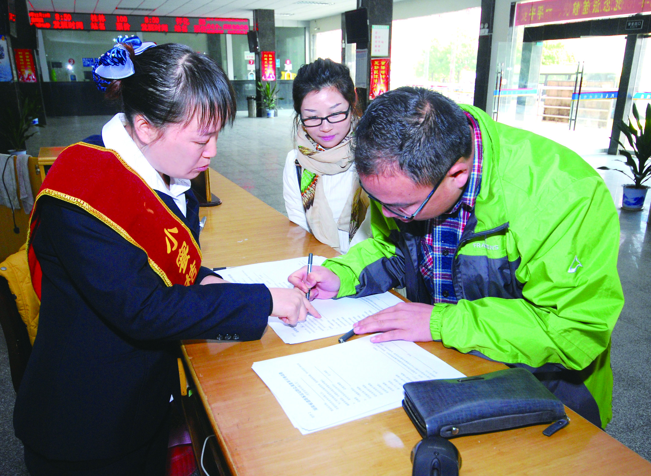 圖為洞口汽車總站站務(wù)人員在熱心為旅客服務(wù)。